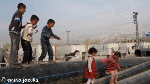 Kurdish children play on drainage pipes outside their temporary homes in earthquake-stricken Van.